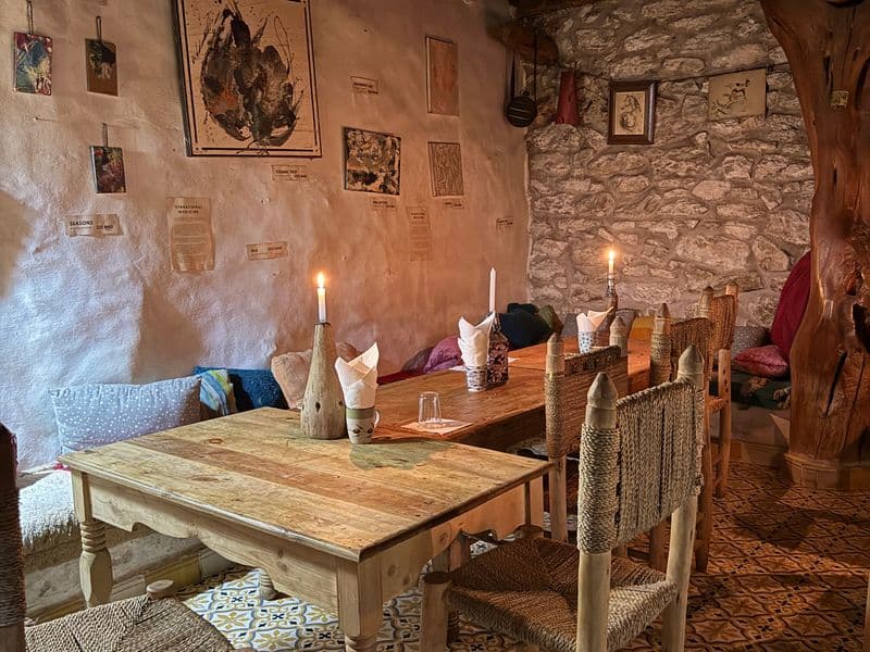 Salle intime aux chandelles, poutres en bois et tables rustiques