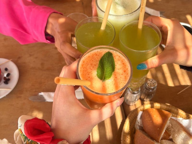 Convives trinquant avec des mocktails frais autour de la table