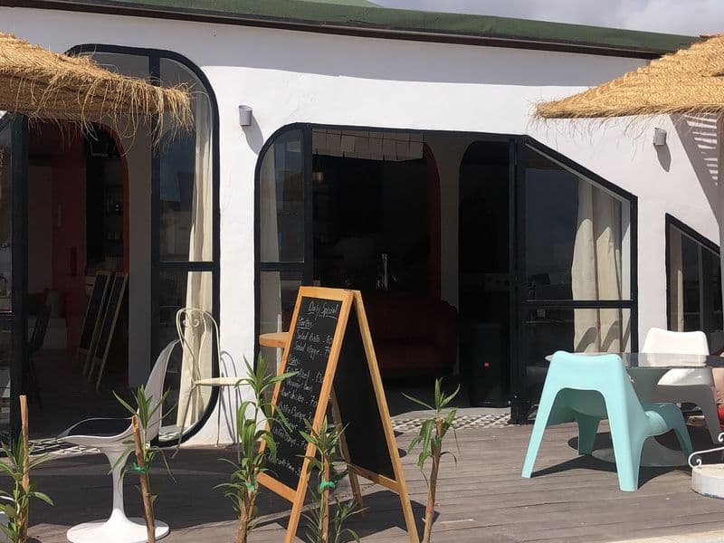 Cour-terrasse bohème avec arbre central et fauteuils en rotin