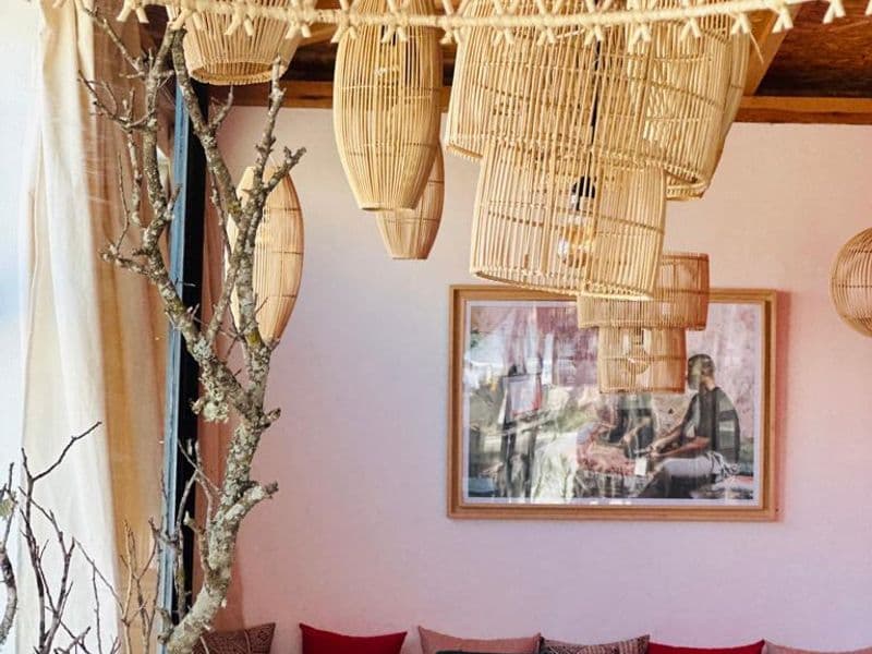 Intérieur chaleureux avec lampes suspendues tressées et banquettes en velours