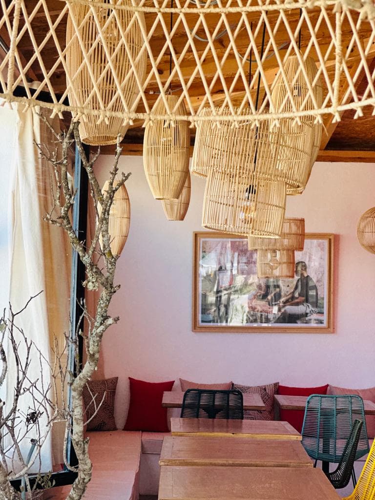 Intérieur chaleureux avec lampes suspendues tressées et banquettes en velours