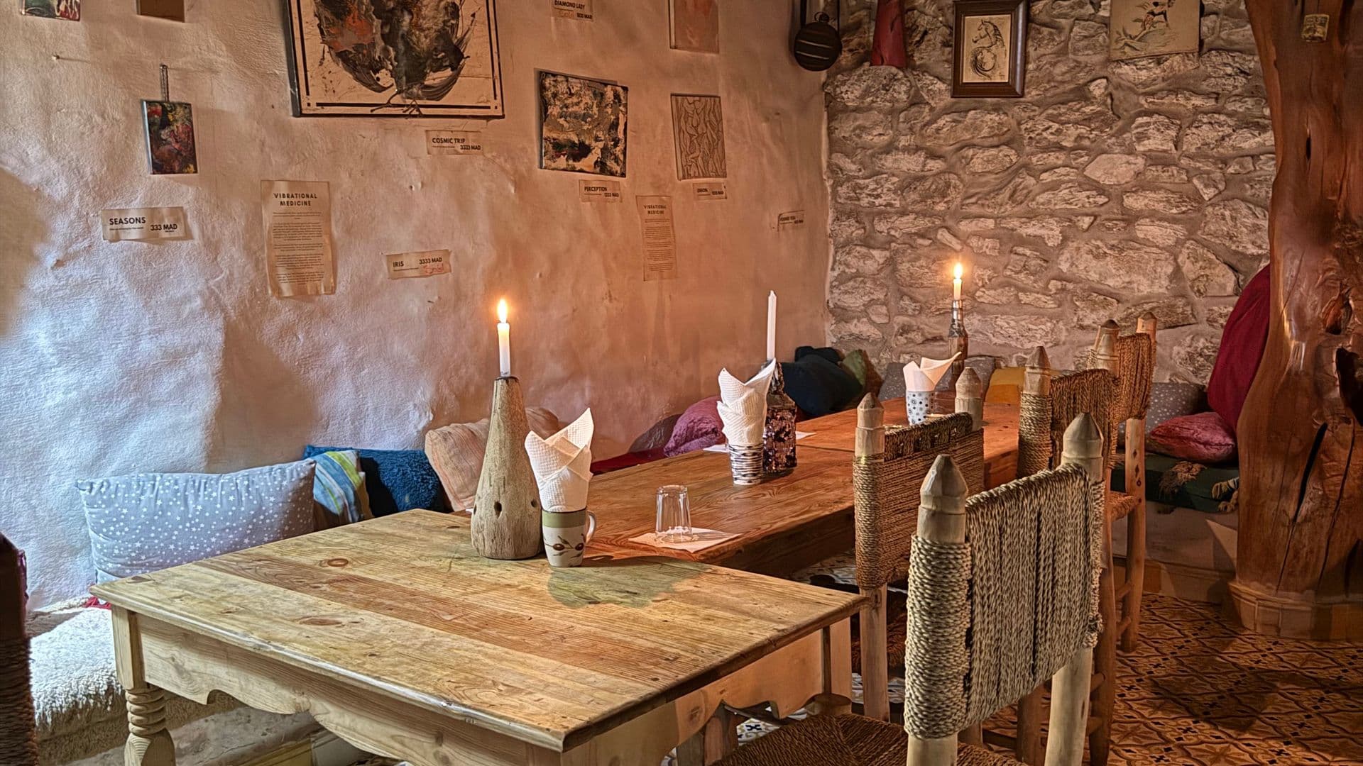 Salle intime aux chandelles, poutres en bois et tables rustiques